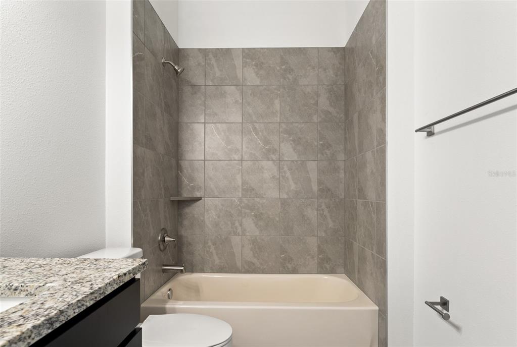 15171 Pomp Parkway Weeki Wachee, FL 34614 - Photo 39 of 50 a bathroom with a granite countertop bathtub shower sink and toilet