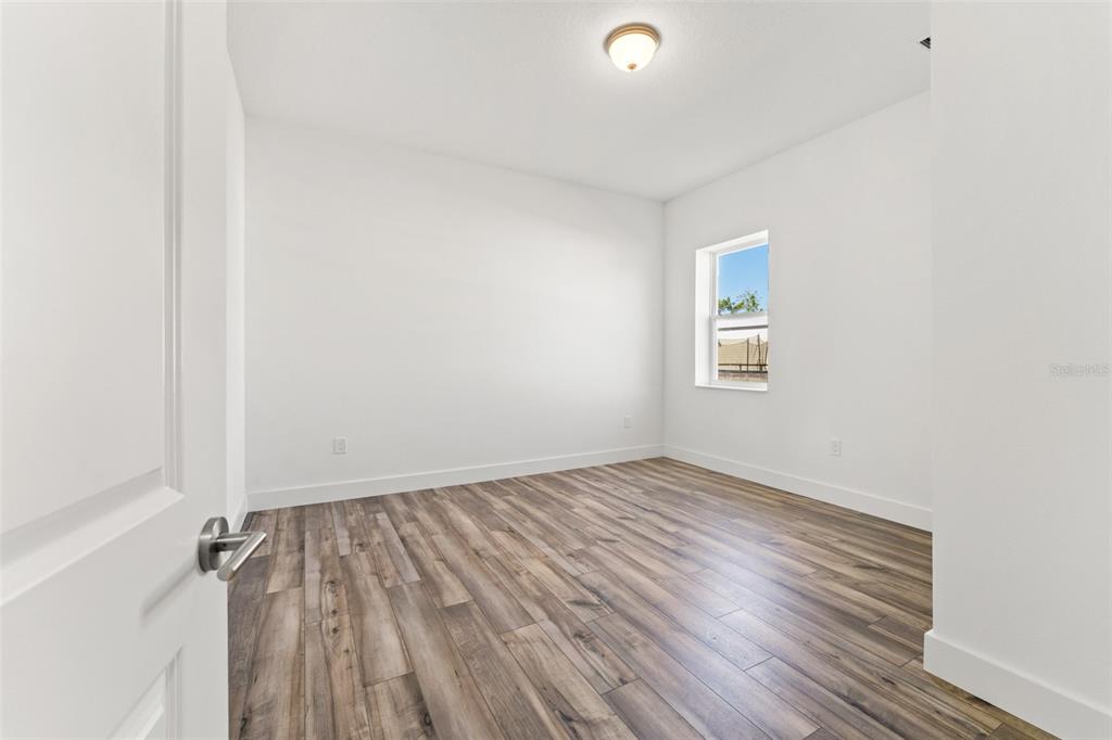 15171 Pomp Parkway Weeki Wachee, FL 34614 - Photo 40 of 50 an empty room with wooden floor and windows