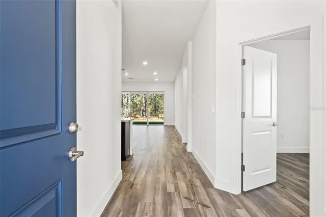 a view of a hallway with wooden floor and closet
