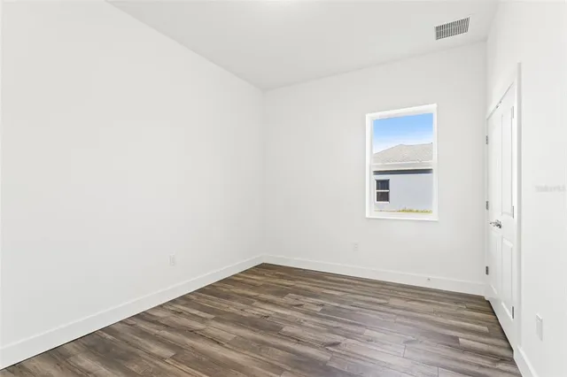 a view of a room with wooden floor and white walls