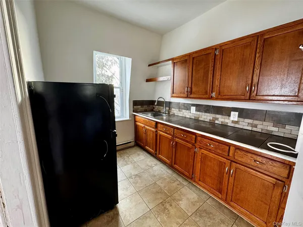 a kitchen with granite countertop stainless steel appliances a refrigerator and a sink