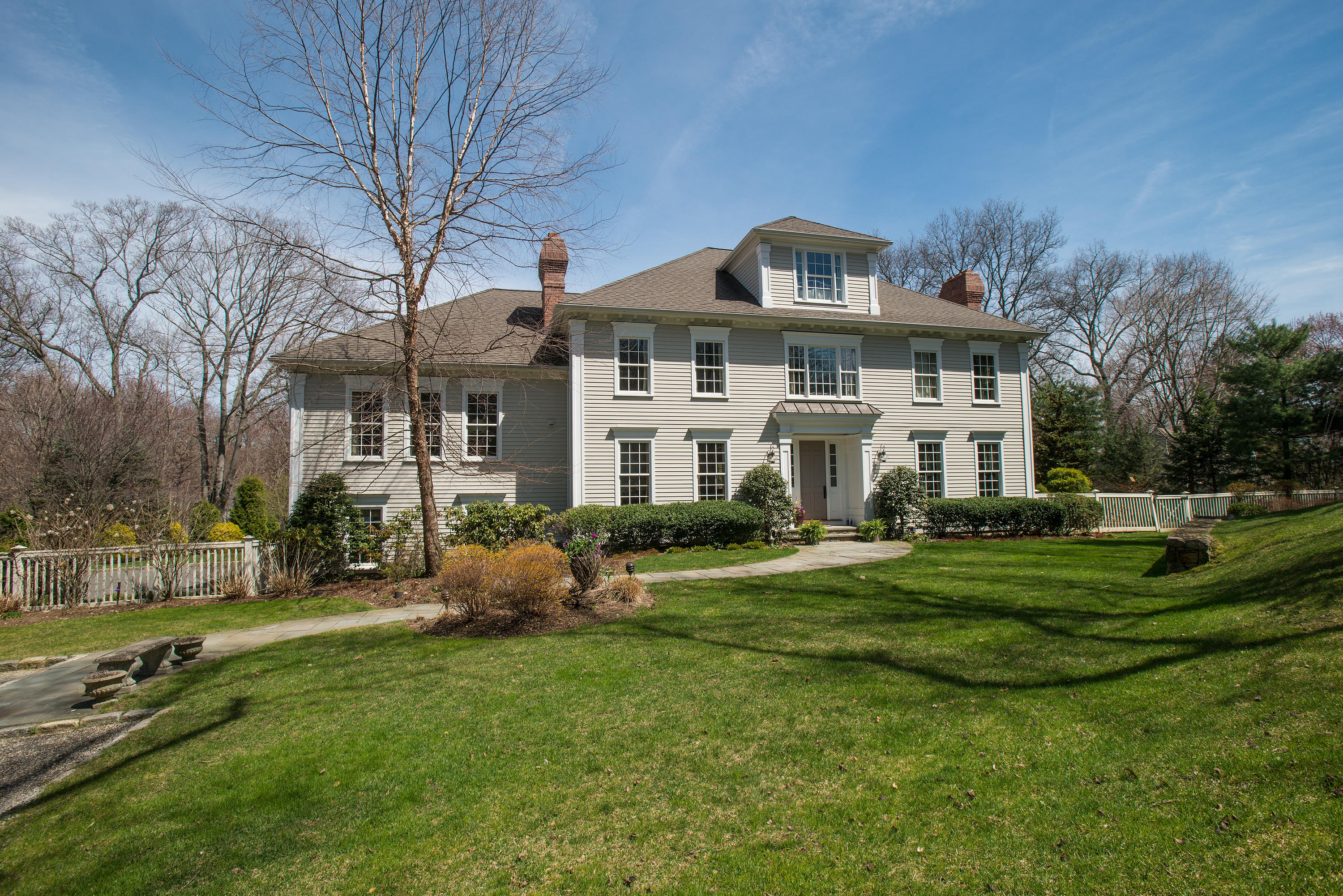 a front view of a house with a garden and trees