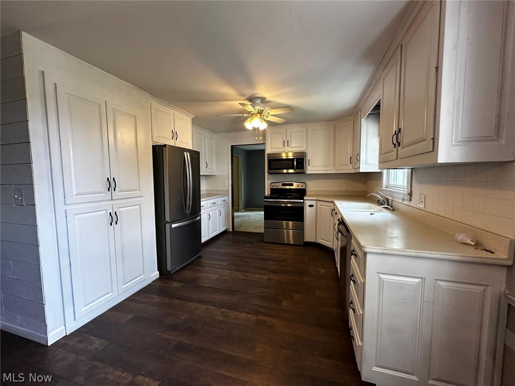 2093 Cambridge Road Coshocton, OH 43812 - Photo 16 of 32 Kitchen with dark hardwood / wood-style flooring, white cabinets, ceiling fan, and stainless steel appliances