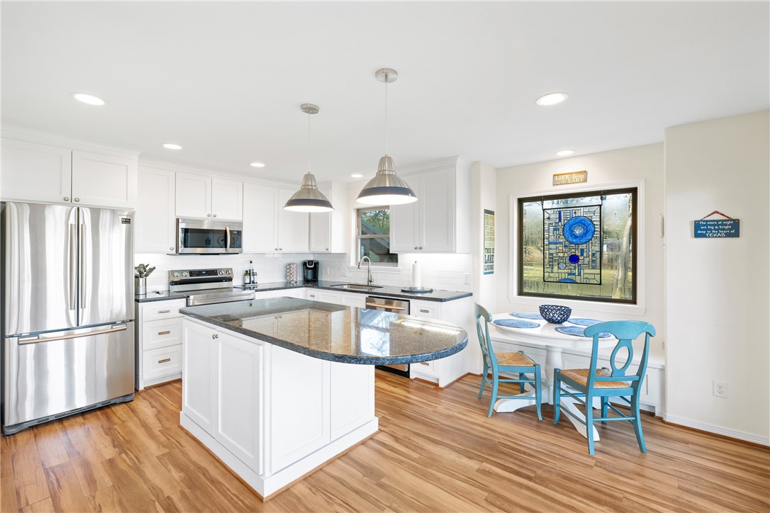 9249 Clyde Acord Road Franklin, TX 77856 - Photo 2 of 23 Kitchen featuring white cabinetry, light wood finished floors, appliances with stainless steel finishes, and a sink