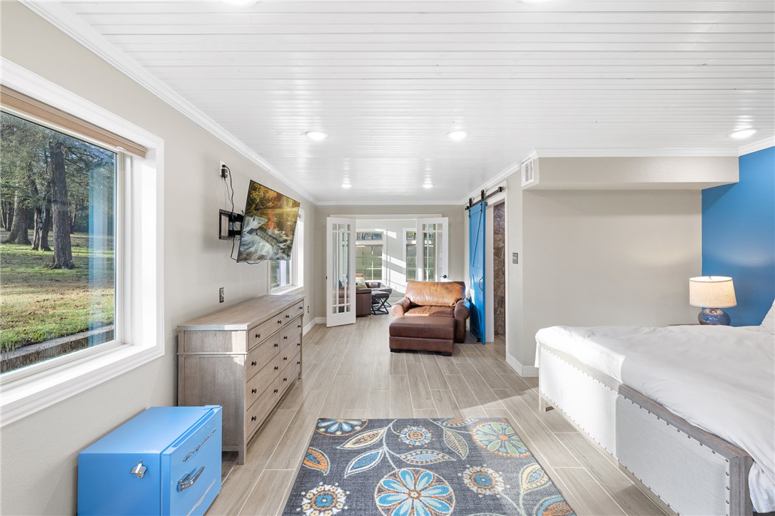 9249 Clyde Acord Road Franklin, TX 77856 - Photo 9 of 23 Bedroom with wood finish floors, baseboards, crown molding, and a barn door