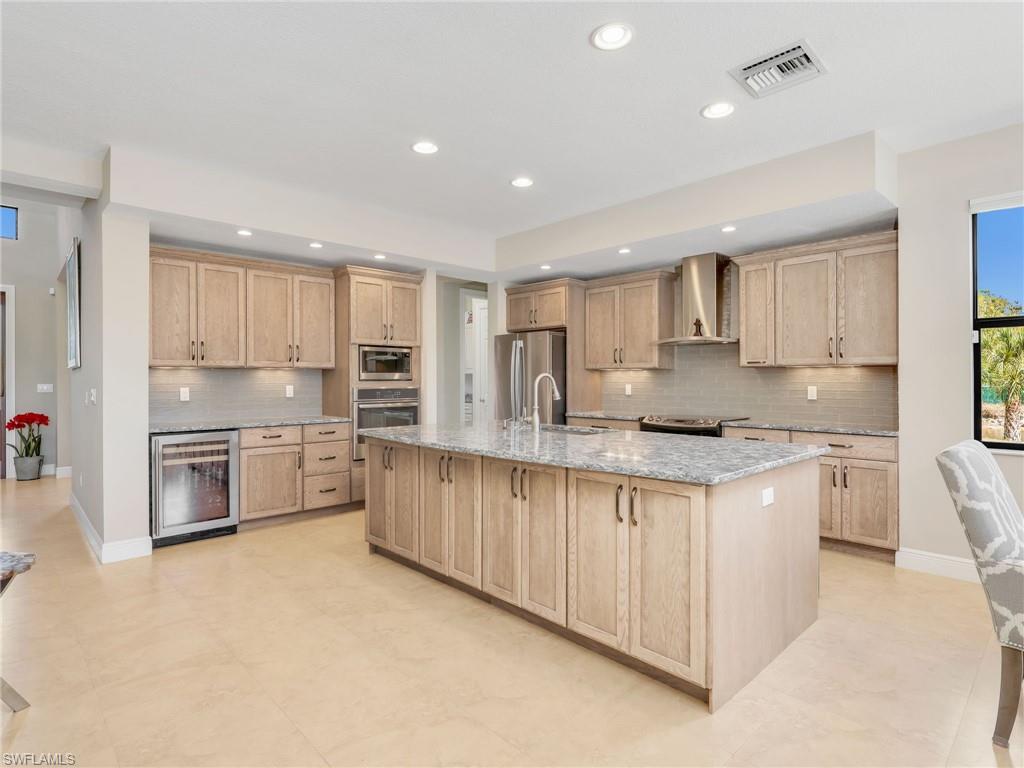 3160 27th Avenue Southwest Naples, FL 34117 - Photo 13 of 43 a large kitchen with stainless steel appliances cabinets a sink and a counter top space