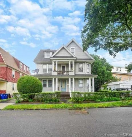 a front view of a house with a yard and trees