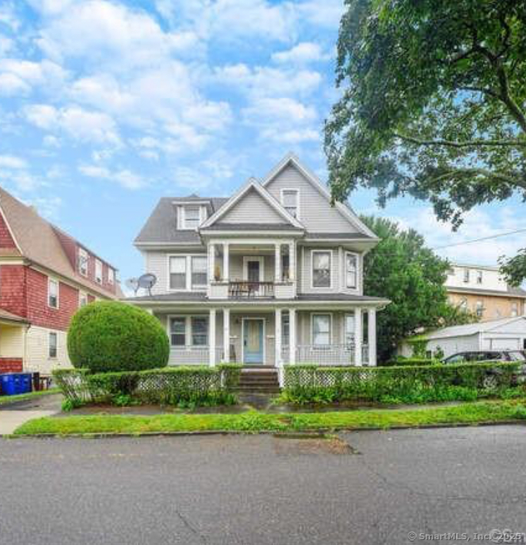 a front view of a house with a yard and trees