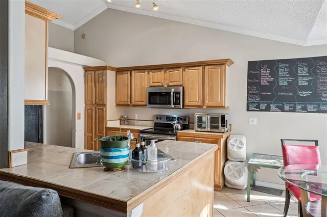 a kitchen with stainless steel appliances granite countertop a sink refrigerator and microwave