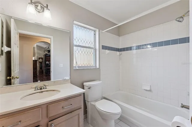a bathroom with a granite countertop sink a toilet and shower