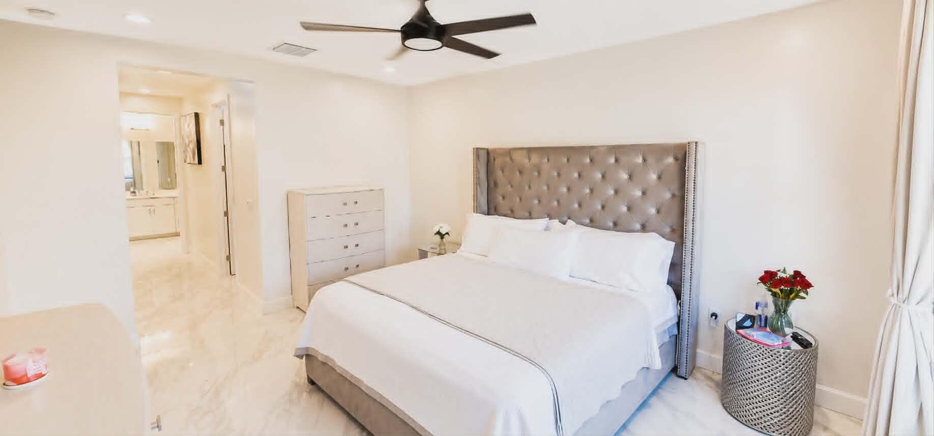 19179 Rolling Acrs Road Loxahatchee, FL 33470 - Photo 26 of 38 a bedroom with a bed and a chandelier