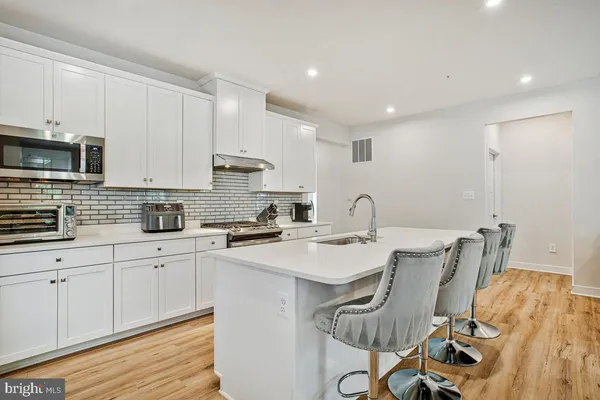 a kitchen with a sink a stove a microwave cabinets and dining table