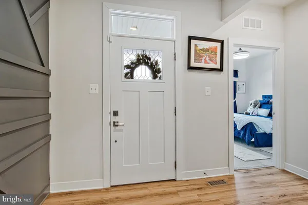 a view of a hallway with wooden floor and closet