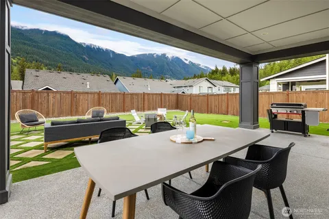 a view of a patio with table and chairs potted plants with wooden floor and fence