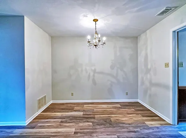a view of a room with wooden floor and chandelier