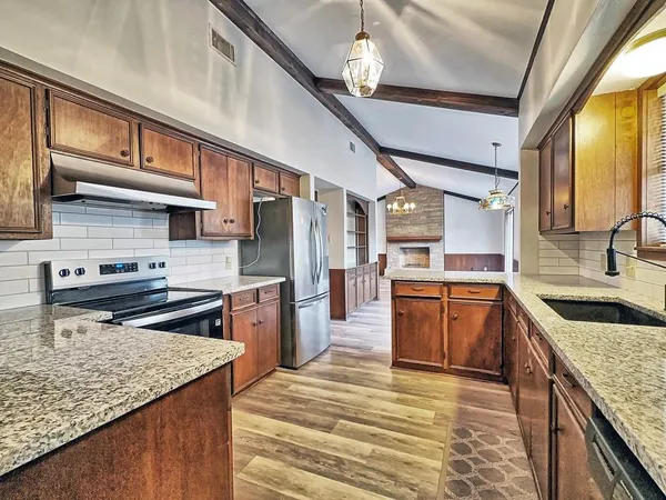 a kitchen with stainless steel appliances granite countertop a sink stove and refrigerator