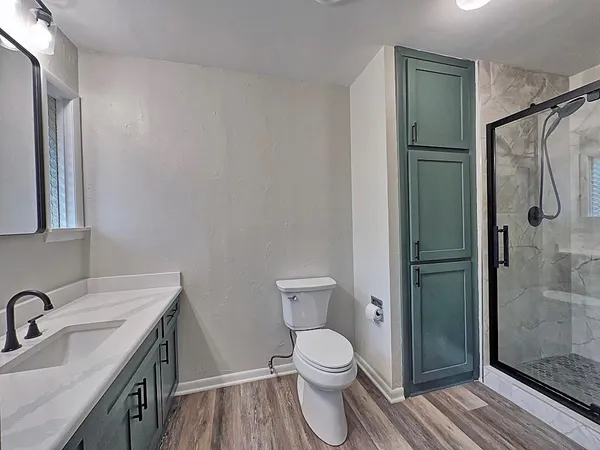 a bathroom with a granite countertop sink toilet and shower