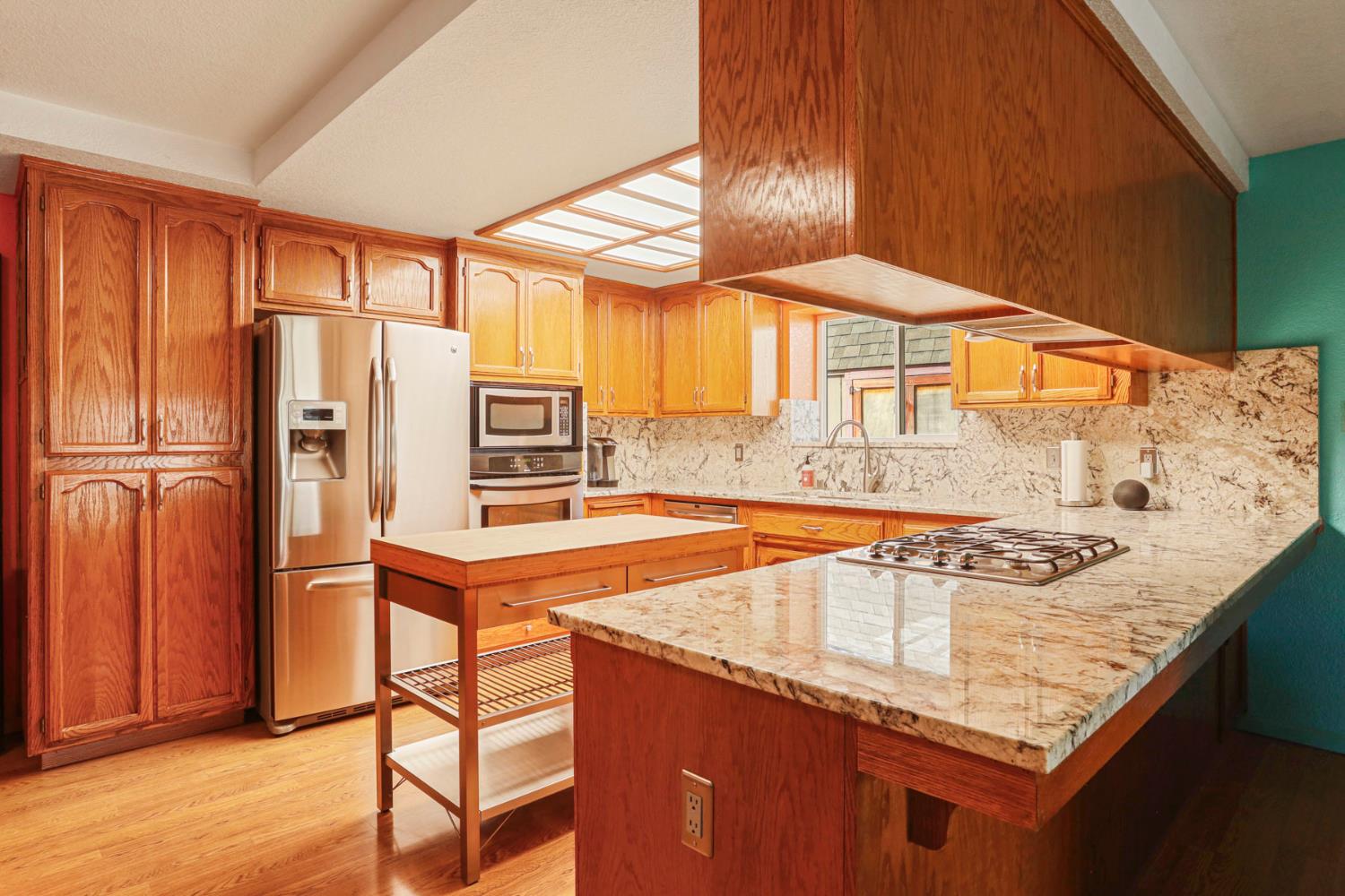 1601 Stanley Drive Ripon, CA 95366 - Photo 12 of 41 an open kitchen with granite countertop a sink and a refrigerator