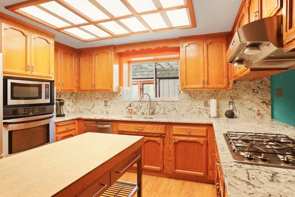 a kitchen with granite countertop a stove a sink and a microwave
