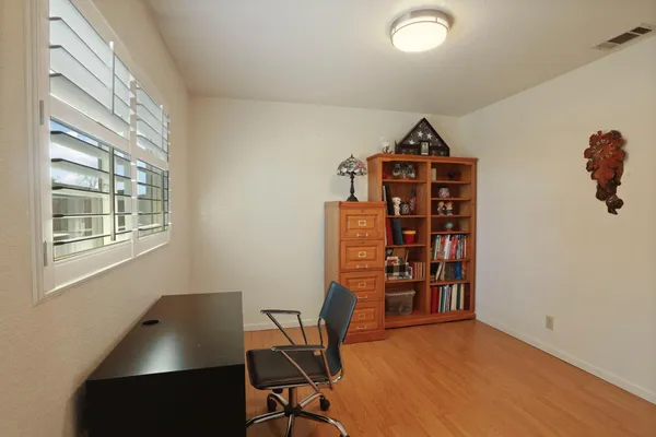 a view of a workspace with furniture and a window