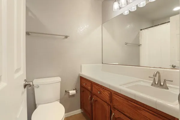 a bathroom with a sink toilet vanity and shower