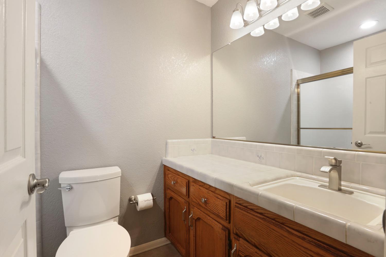 1601 Stanley Drive Ripon, CA 95366 - Photo 28 of 41 a bathroom with a sink a toilet and a mirror