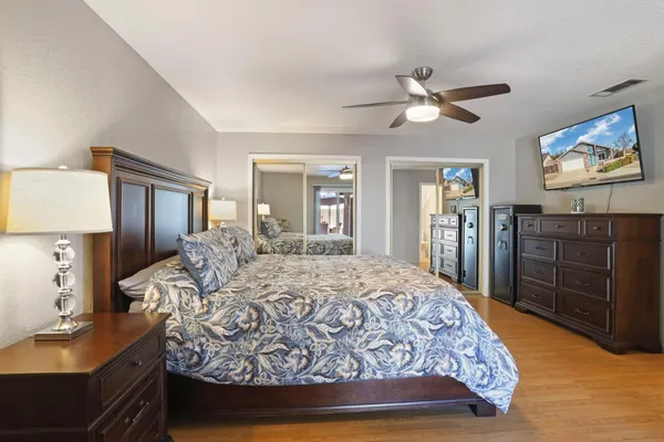 a bedroom with a bed and dresser with mirror