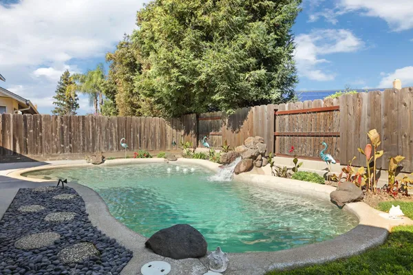 a view of a backyard with swimming pool