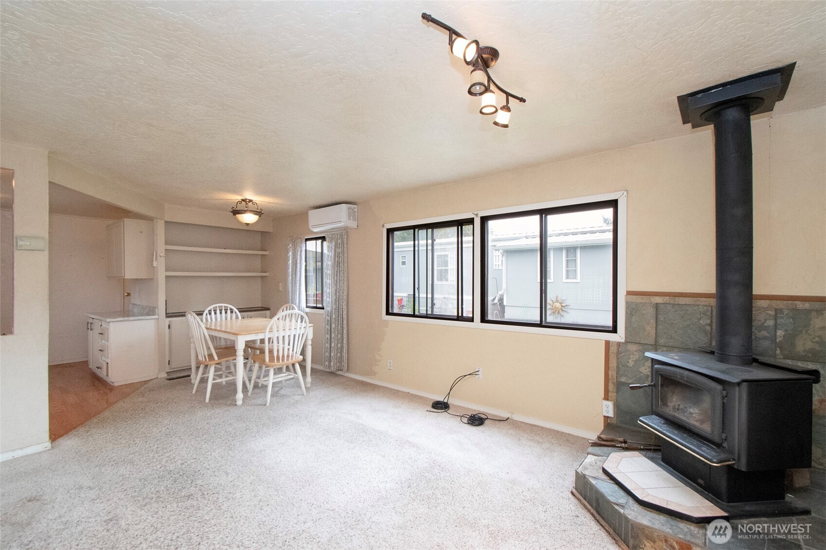 90 Baywood Village Road, Unit 34 Sequim, WA 98382 - Photo 11 of 40 a living room with furniture a flat screen tv and a fireplace