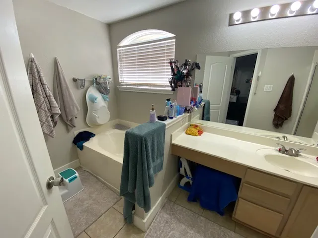 a bathroom with a sink mirror and a window