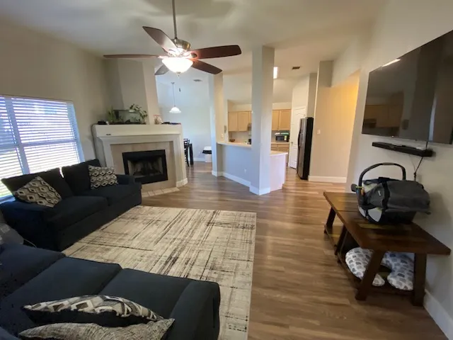 a living room with furniture a flat screen tv and a fireplace