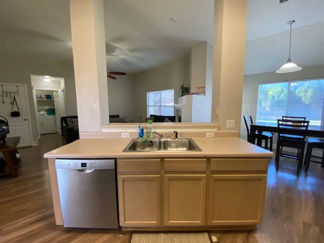 a room with kitchen island a wooden floor and white appliances