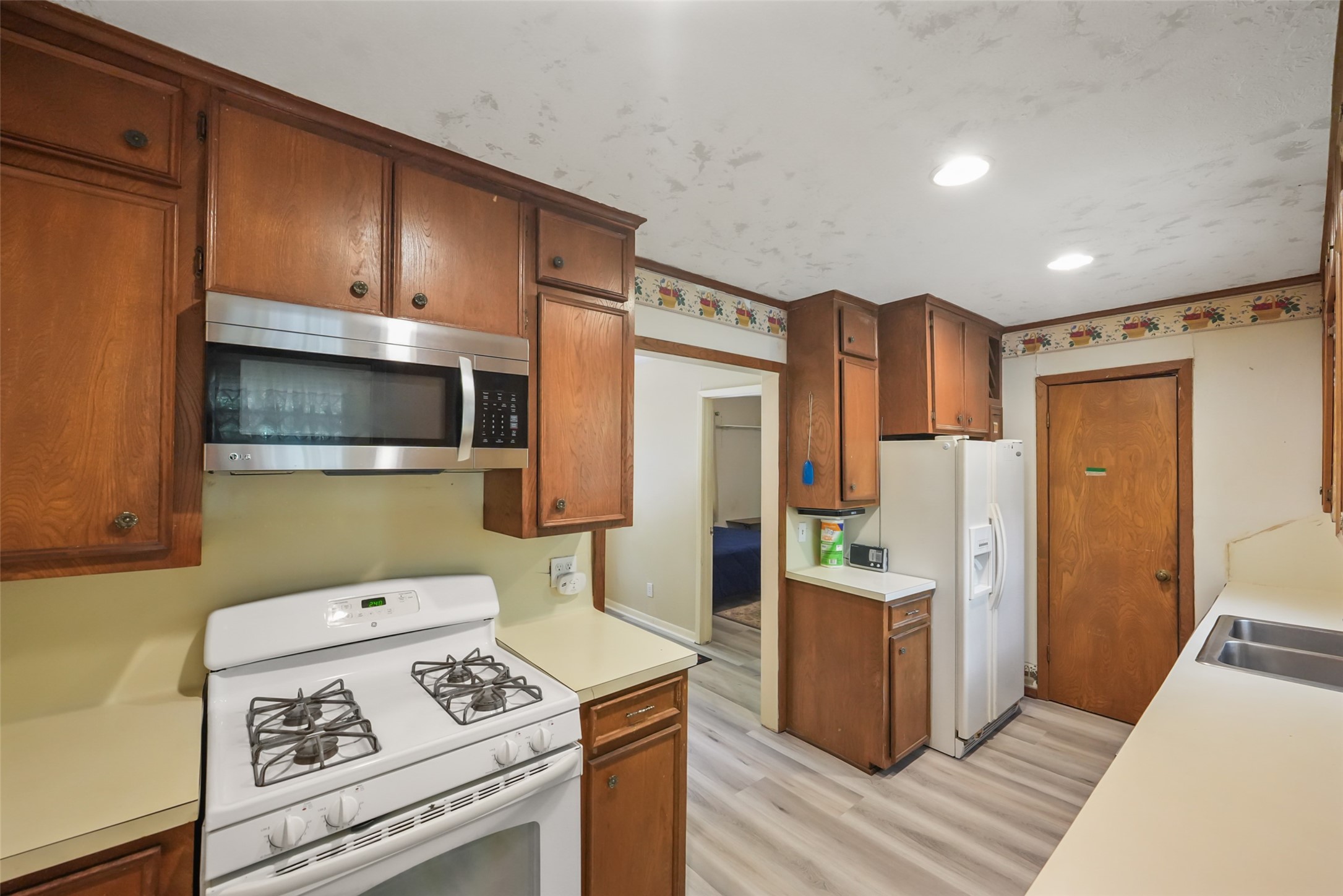 6387 Oak Knoll Road Montgomery, TX 77316 - Photo 12 of 30 a kitchen with stainless steel appliances a stove a microwave and a refrigerator