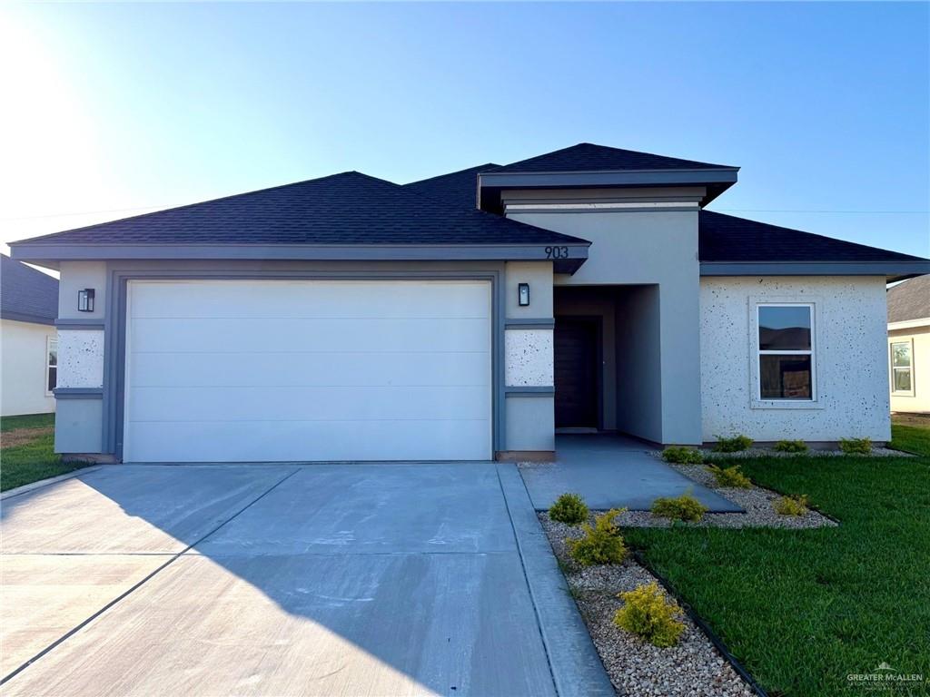 a view of front of a house with a yard and garage