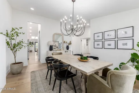 a view of a dining room with furniture a chandelier and wooden floor