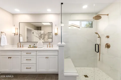 a bathroom with a double vanity sink a toilet a mirror and shower