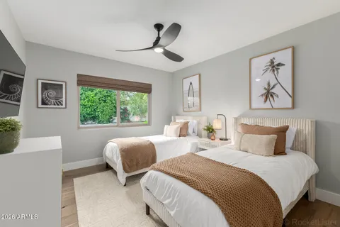 a bedroom with two beds and a large window