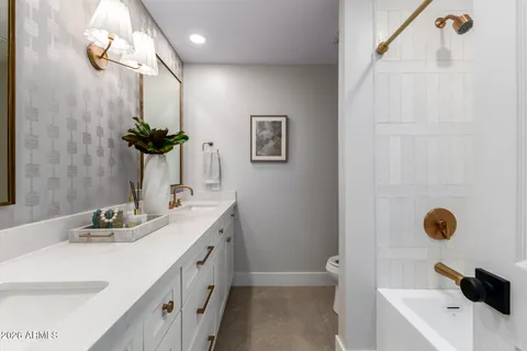 a bathroom with a double vanity sink a mirror and shower