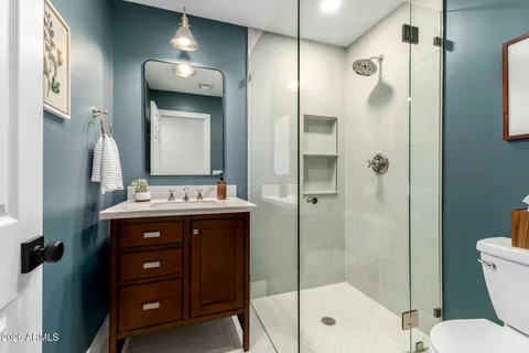 a bathroom with a shower sink vanity and mirror