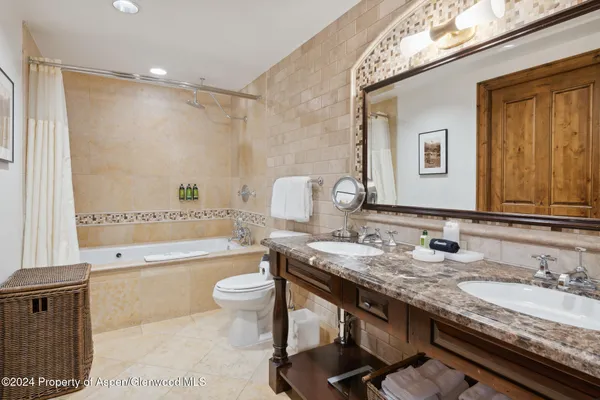a bathroom with a granite countertop sink a toilet and bathtub