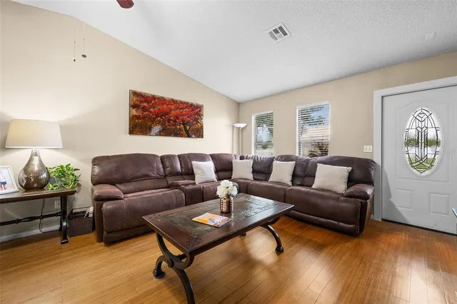 a living room with furniture and a wooden floor