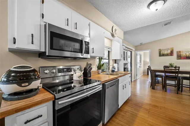 a kitchen with stainless steel appliances a stove microwave and cabinets