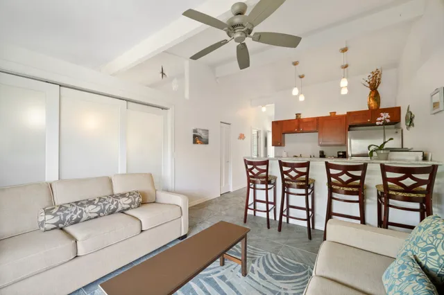 a living room with furniture a ceiling fan and a rug