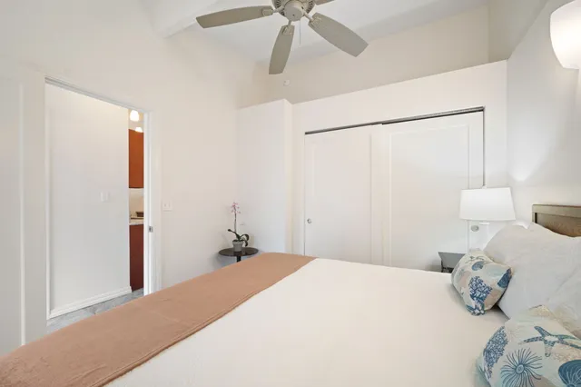 a bedroom with a bed and a chandelier fan