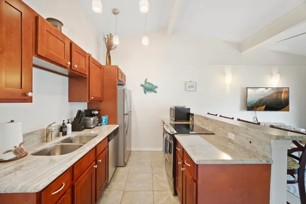 a kitchen with stainless steel appliances granite countertop a sink and a refrigerator