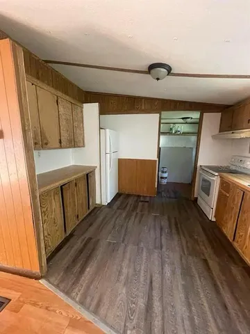 a view of a kitchen with wooden floor and electronic appliances