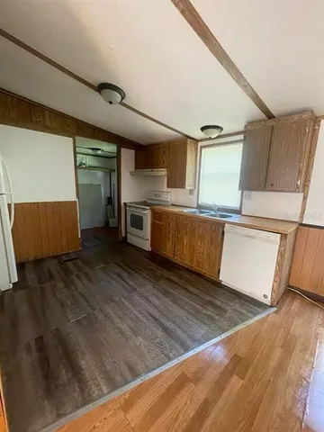 a view of a kitchen with wooden floor and electronic appliances