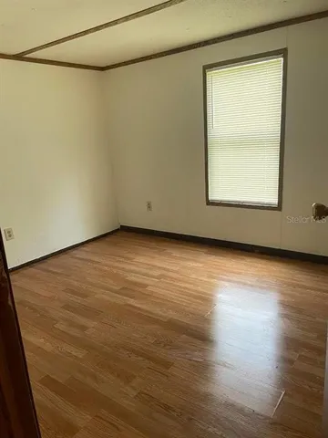 a view of a room with wooden floor and a window