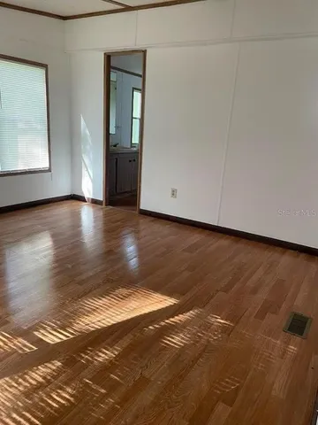 a view of a livingroom with wooden floor and a window