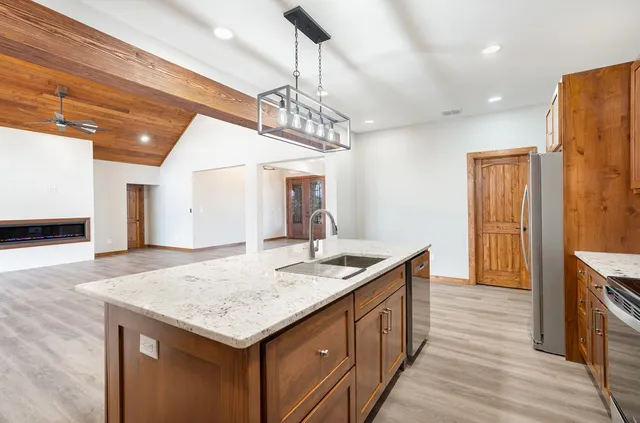 a kitchen with a sink a counter space and wooden floor